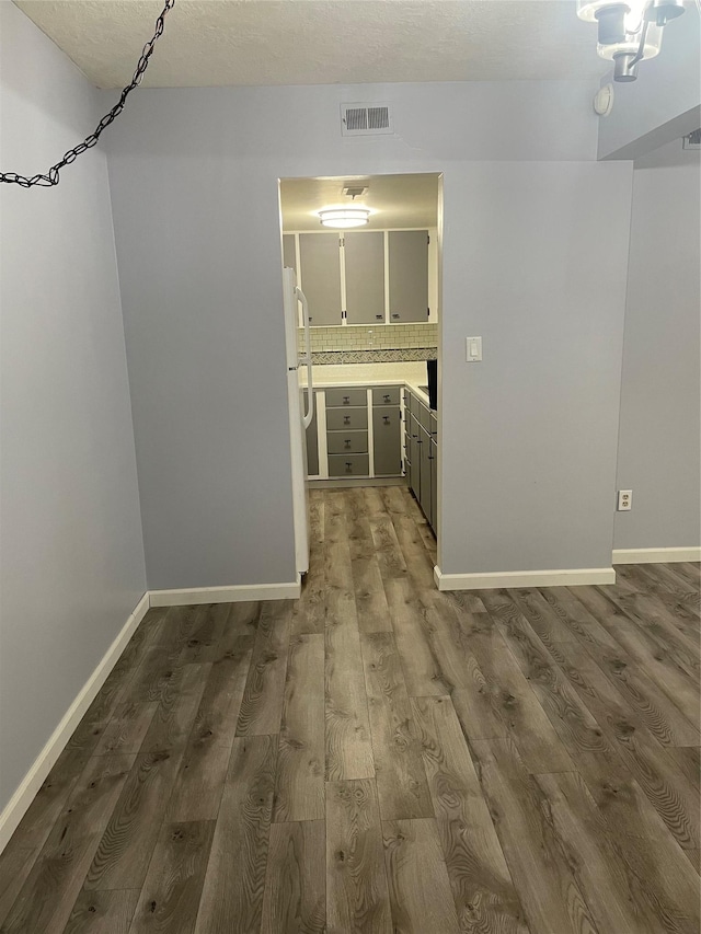 hallway featuring a textured ceiling and hardwood / wood-style flooring