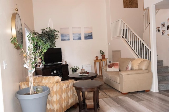 living room with hardwood / wood-style floors and a high ceiling