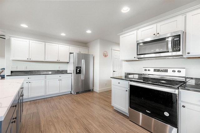 kitchen with appliances with stainless steel finishes, light wood-type flooring, and white cabinetry