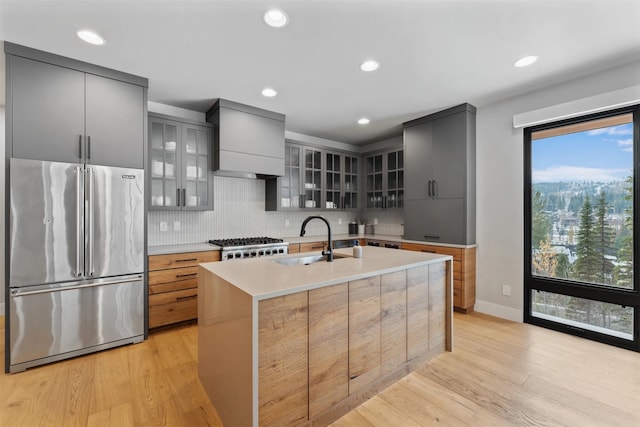 1148 Glades Dr, Whitefish, MT 59937 - kitchen with gray cabinetry, sink, a kitchen island with sink, high end fridge, and light wood-type flooring