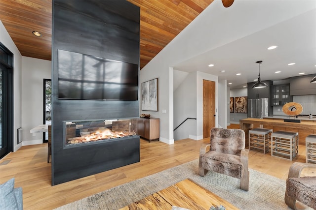 1148 Glades Dr, Whitefish, MT 59937 - living room with a multi sided fireplace, light hardwood / wood-style floors, lofted ceiling, and wood ceiling