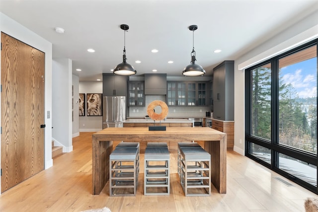 1148 Glades Dr, Whitefish, MT 59937 - kitchen featuring tasteful backsplash, high end refrigerator, light hardwood / wood-style flooring, decorative light fixtures, and gray cabinets