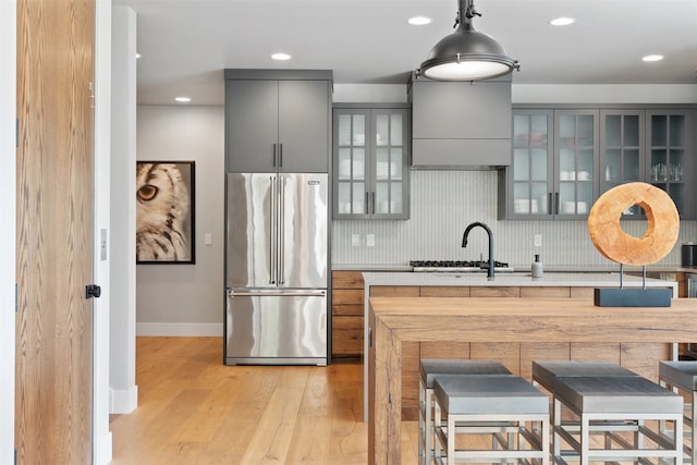 1148 Glades Dr, Whitefish, MT 59937 - kitchen featuring tasteful backsplash, light hardwood / wood-style flooring, gray cabinets, built in refrigerator, and hanging light fixtures