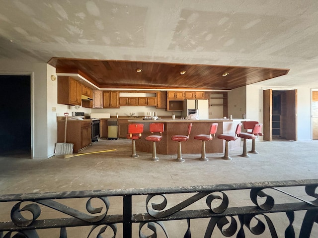 kitchen featuring a breakfast bar, white fridge with ice dispenser, and electric range oven