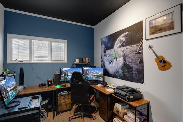 home office with light hardwood / wood-style floors and ornamental molding