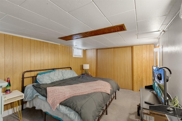 carpeted bedroom featuring wood walls