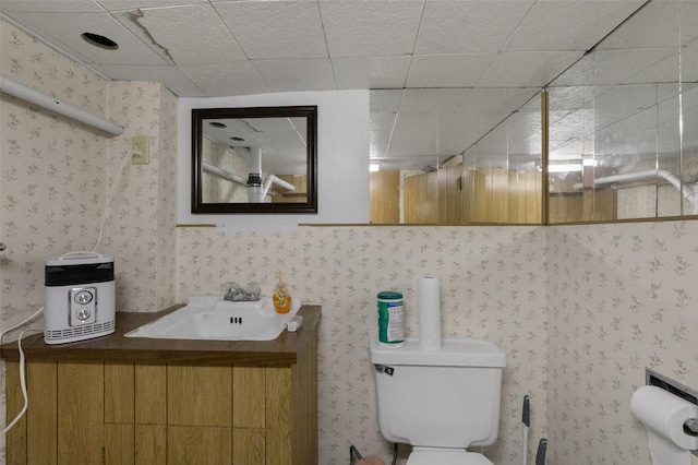 bathroom featuring a paneled ceiling, vanity, and toilet