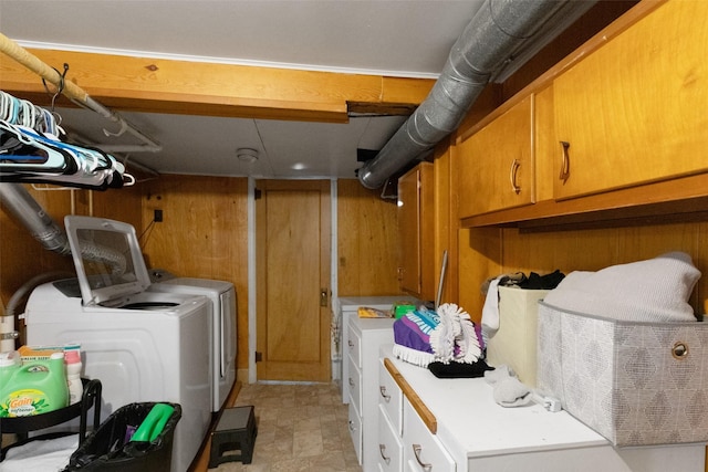 washroom featuring cabinets, independent washer and dryer, and wood walls