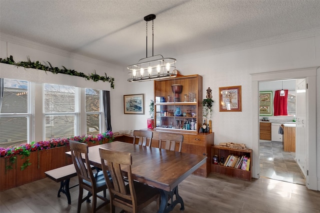 dining area with hardwood / wood-style flooring, a notable chandelier, and a textured ceiling