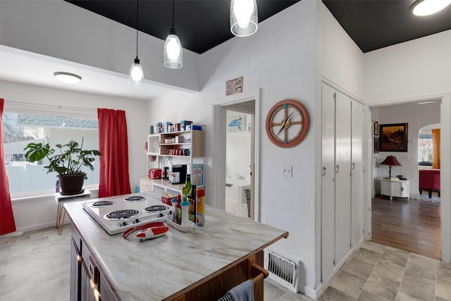 kitchen featuring decorative light fixtures, white stovetop, and light hardwood / wood-style flooring