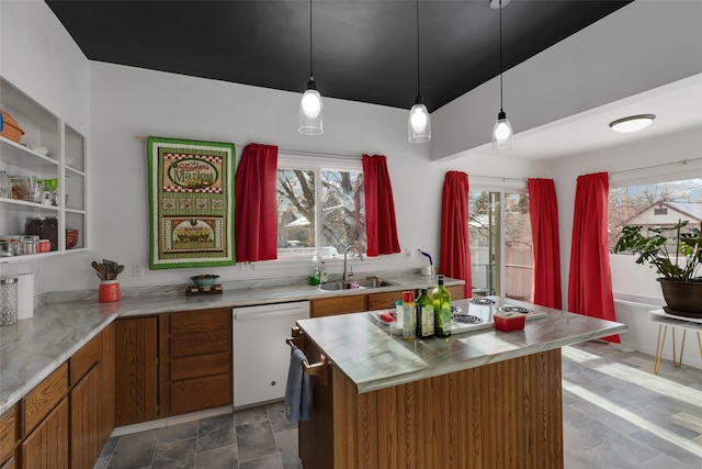 kitchen with sink, white dishwasher, pendant lighting, stainless steel stovetop, and a kitchen island