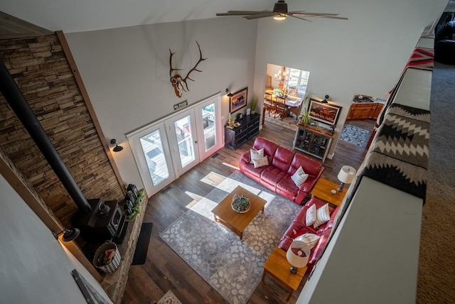 living room featuring a wood stove, high vaulted ceiling, french doors, and dark wood-type flooring