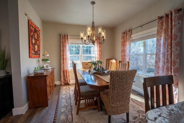 dining room with hardwood / wood-style flooring, a notable chandelier, and a healthy amount of sunlight