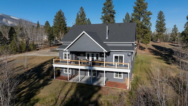 back of house with a deck with mountain view, a yard, and a patio