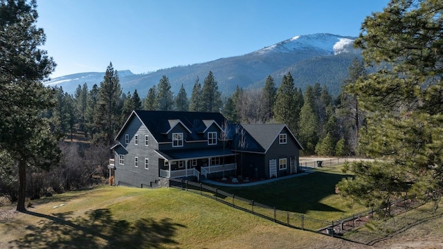 rear view of house featuring a lawn and a mountain view