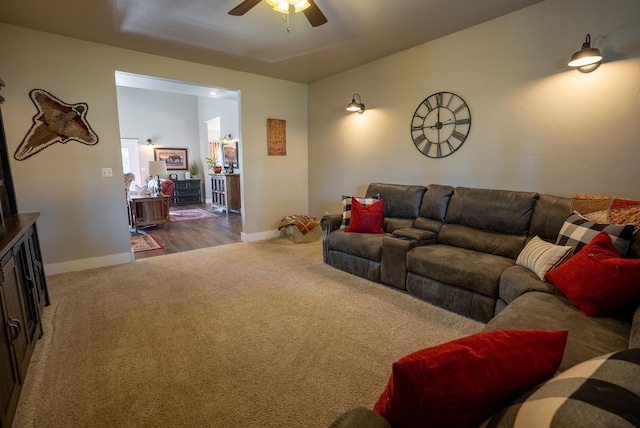 carpeted living room with ceiling fan