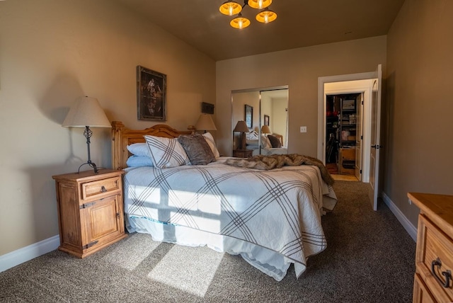 bedroom featuring dark carpet, an inviting chandelier, and a closet