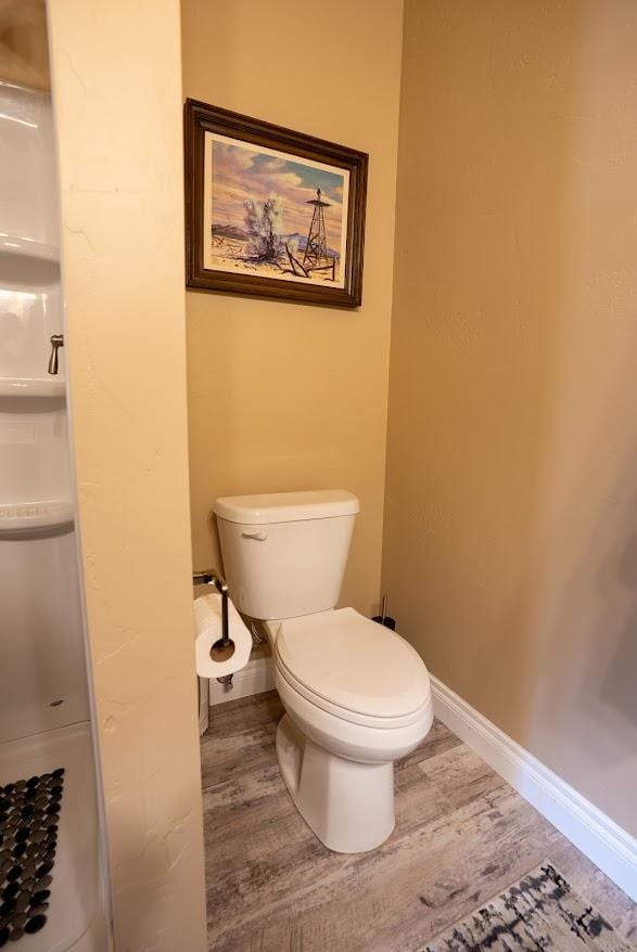 bathroom featuring hardwood / wood-style flooring and toilet