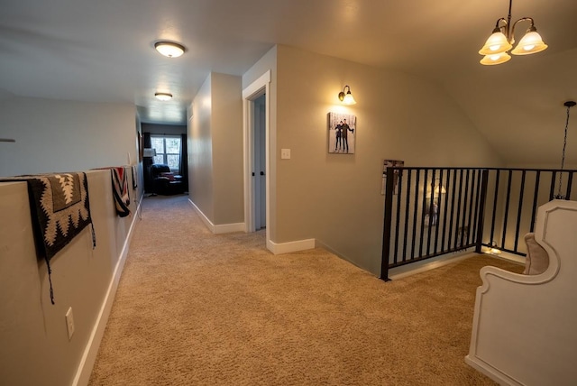 hallway with light colored carpet, lofted ceiling, and an inviting chandelier