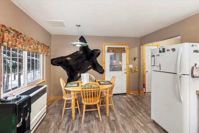 dining space featuring dark wood-type flooring and heating unit