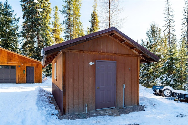 snow covered structure with a garage