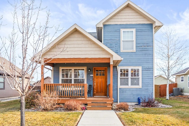 view of front of house featuring covered porch, central AC, and a front lawn