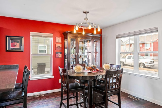 dining space featuring dark hardwood / wood-style floors and a notable chandelier