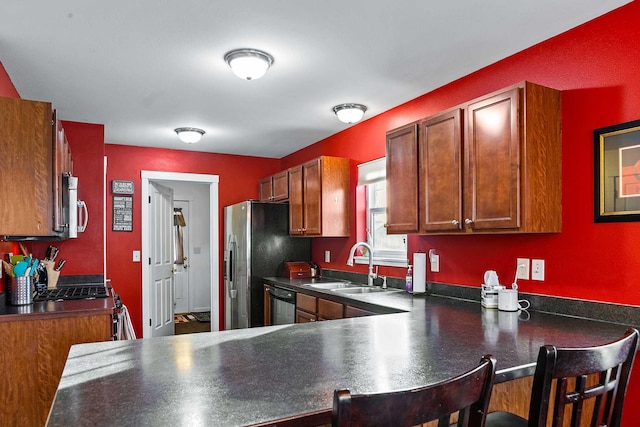 kitchen with a breakfast bar area, kitchen peninsula, sink, and appliances with stainless steel finishes