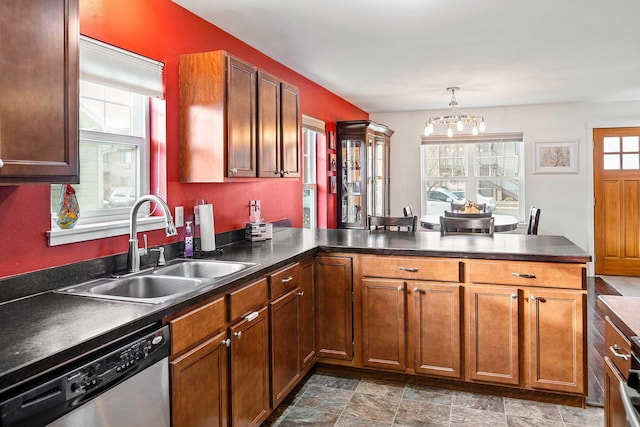 kitchen with kitchen peninsula, stainless steel dishwasher, and a healthy amount of sunlight