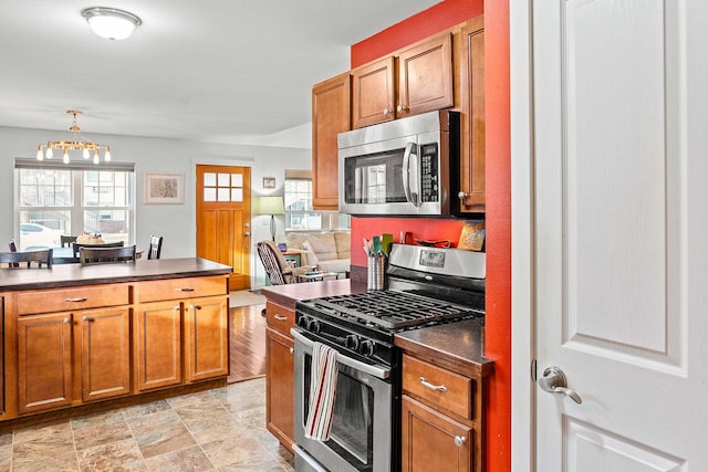 kitchen featuring decorative light fixtures, light hardwood / wood-style flooring, appliances with stainless steel finishes, and an inviting chandelier