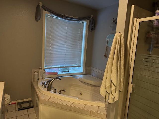 bathroom featuring tile patterned flooring, independent shower and bath, and toilet