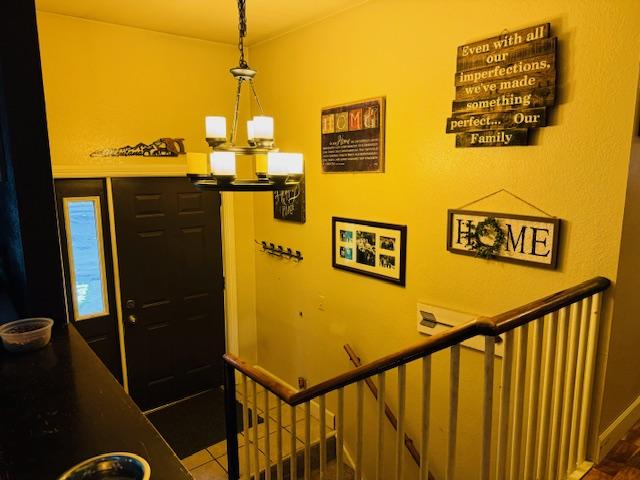 staircase featuring an inviting chandelier