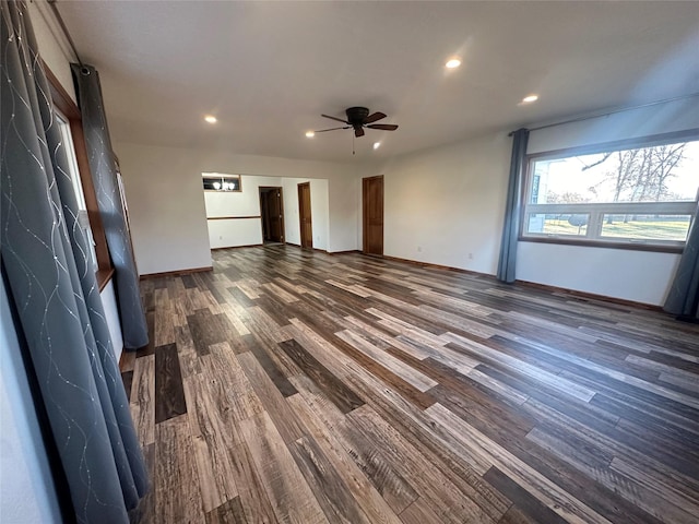 unfurnished living room featuring ceiling fan and dark wood-type flooring