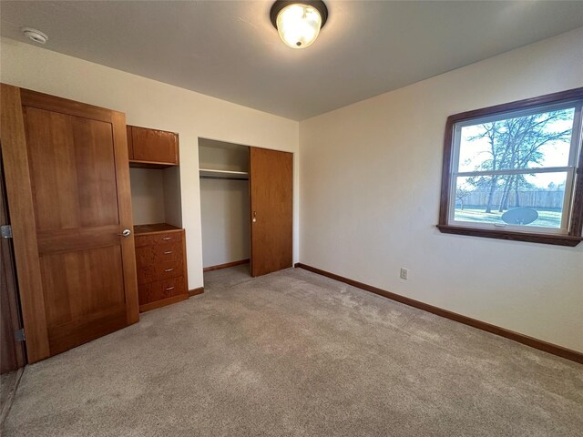 unfurnished bedroom with light colored carpet and a closet