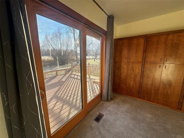 doorway to outside featuring light colored carpet