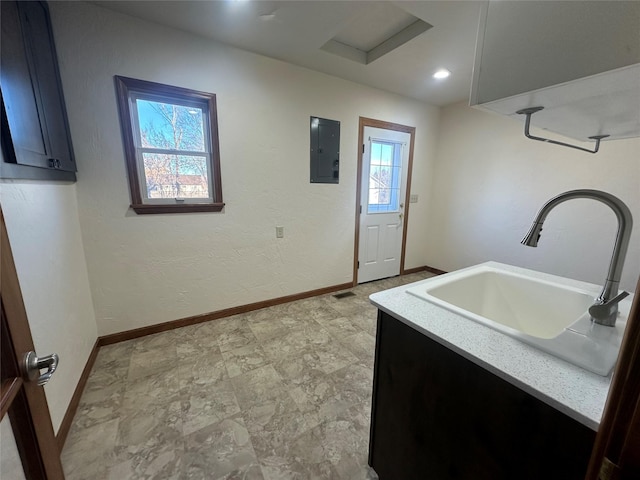 washroom with electric panel, sink, and a healthy amount of sunlight