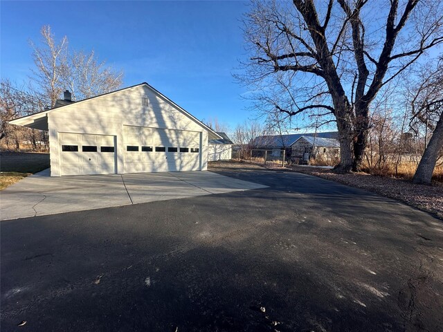 view of property exterior featuring a garage and an outdoor structure