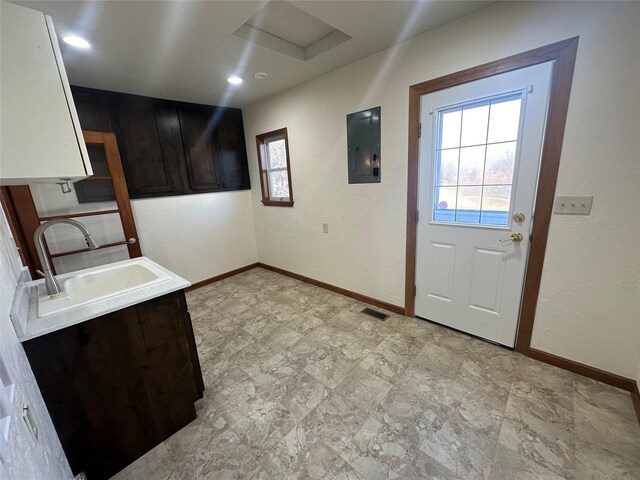 interior space featuring dark brown cabinetry, electric panel, and sink