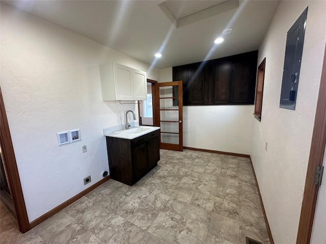 kitchen featuring white cabinetry, sink, and dark brown cabinets