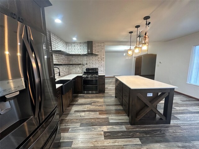 kitchen featuring dark hardwood / wood-style flooring, backsplash, wall chimney exhaust hood, stainless steel appliances, and decorative light fixtures