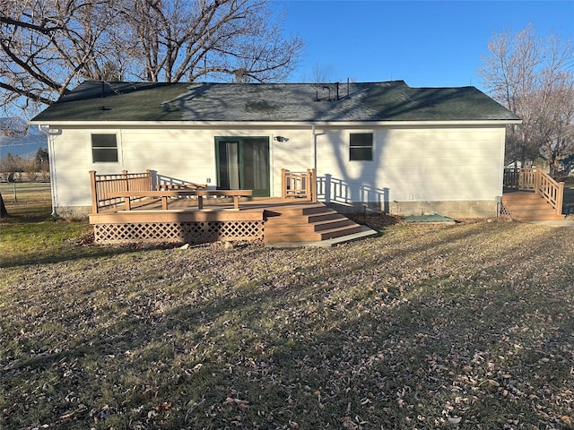 rear view of property with a yard and a deck