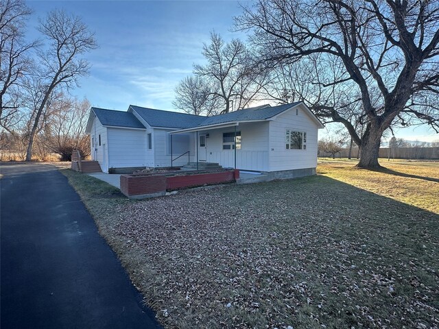 ranch-style house with a porch and a front yard