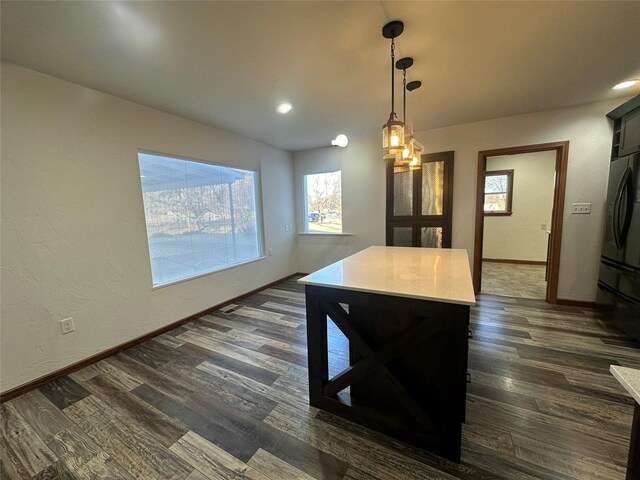 kitchen featuring pendant lighting, plenty of natural light, and dark wood-type flooring