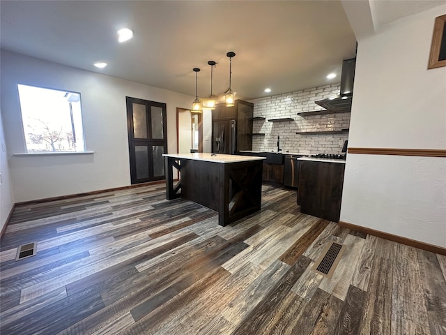 206 Kurtz Ln, Hamilton, MT 59840 - kitchen with black refrigerator with ice dispenser, light countertops, a breakfast bar area, a center island, and dark wood-type flooring