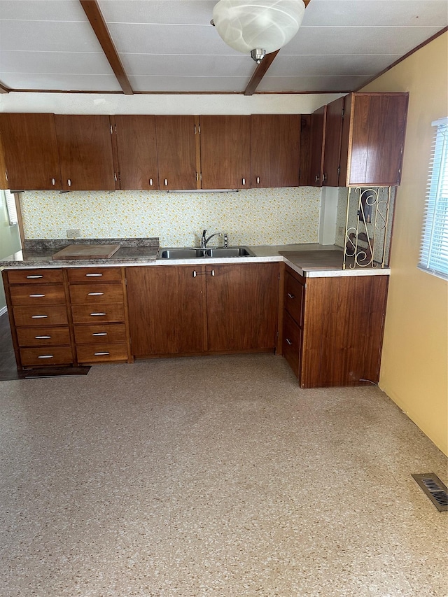 kitchen featuring decorative backsplash, cooktop, and sink