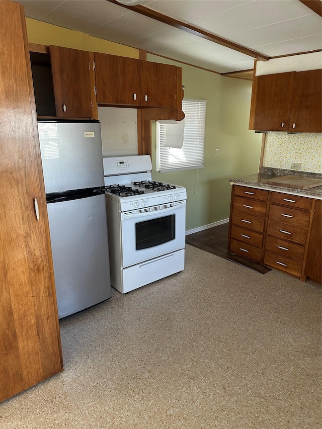 kitchen with stainless steel fridge, backsplash, and gas range gas stove