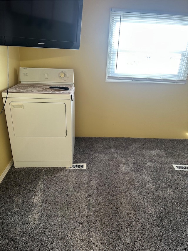 laundry room featuring dark carpet and washer / dryer