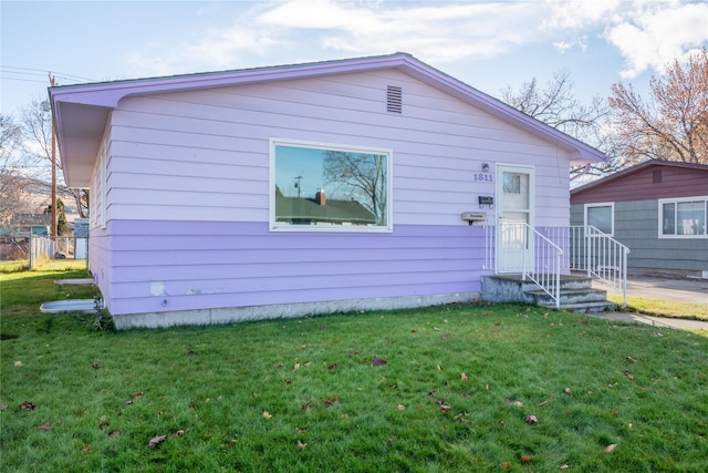 back of property featuring a lawn