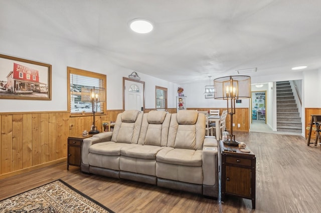 living room with wooden walls, hardwood / wood-style floors, and a chandelier