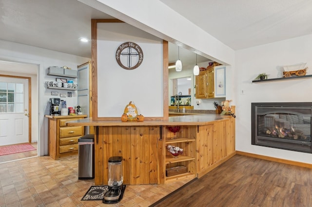 bar featuring decorative light fixtures and light hardwood / wood-style floors